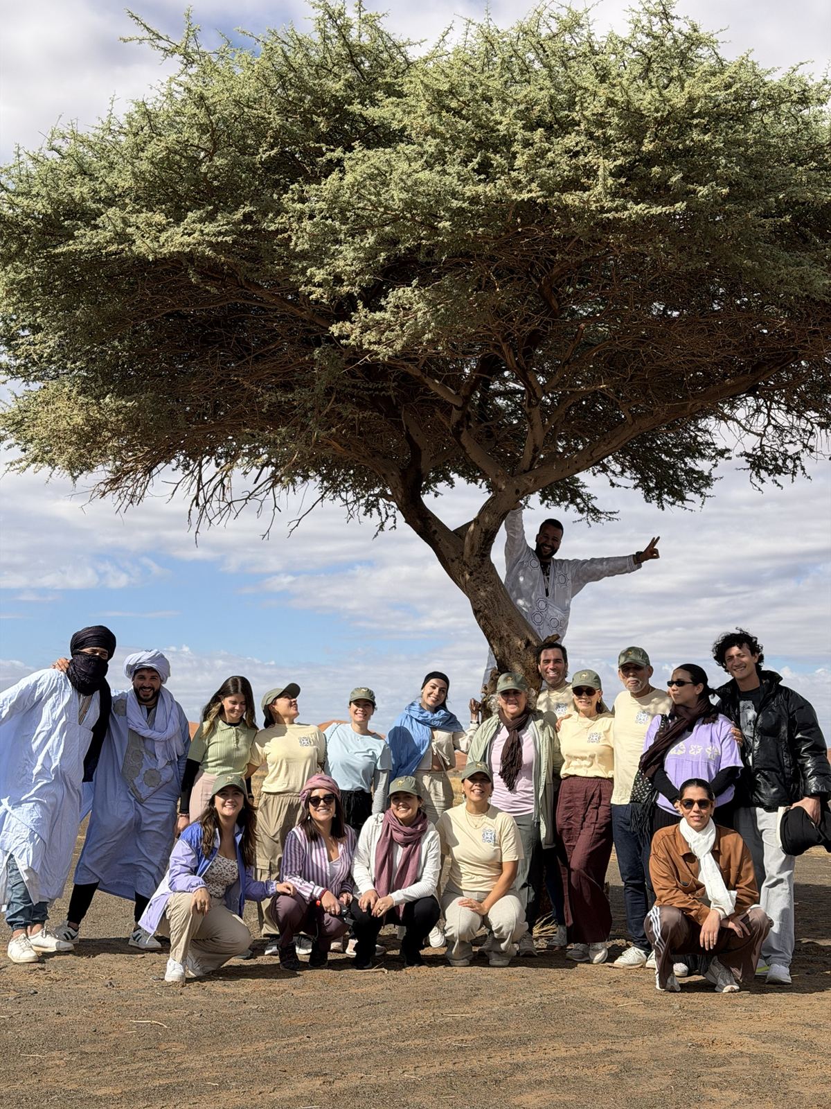Viajeros y guías bajo una acacia en el desierto de Merzouga